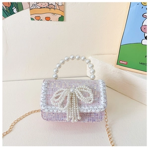 Detail of pink tweed girl's bag with pearl handle, bow, and delicate lace edges