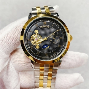 Detail of mechanical watch face with gold Roman numerals and moon phase display