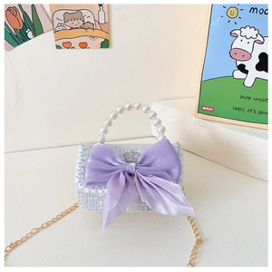 Close-up of glittery purple girls' bag with pearl handle and tulle bow detail