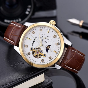 Macro view of mechanical watch face with moon phase and brown leather strap detail