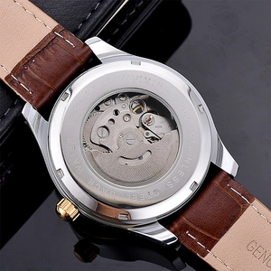 Detail of automatic mechanical watch case back with transparent movement and leather strap