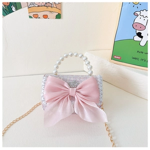 Detail of pink tweed girl bag with large chiffon bow and white pearl handle