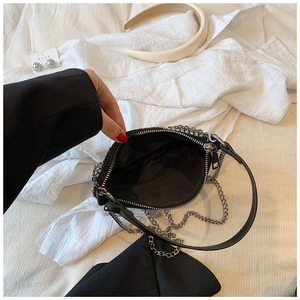 Detail of girls mini black handbag with silver rhinestones and metal chain strap