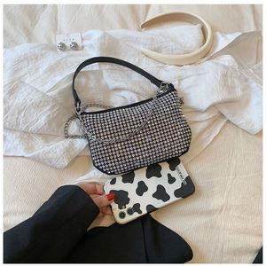 Detail of silver rhinestone crossbody bag with leather strap and decorative metal chain
