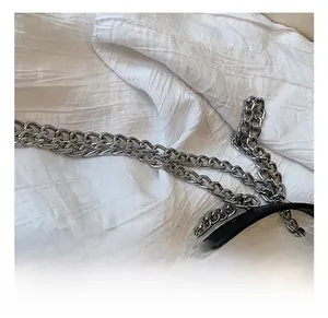 Detail der silbernen Metallkette und der schwarzen Ledernaht einer Mädchen-Umhängetasche