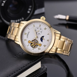 Macro detail of men's automatic watch with gold steel band and moon phase dial