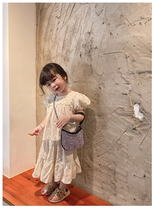 Detail of cream puff-sleeve top with floral embroidery and tiered skirt for girls