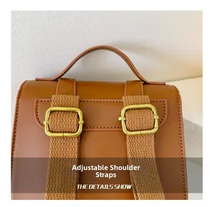 Detail of adjustable shoulder straps with gold metal buckles on a brown leather backpack