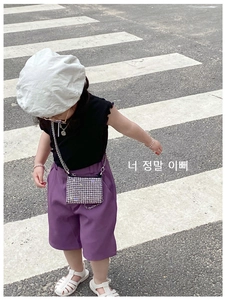 Mini silver rhinestone handbag and stylish summer outfit for girls on an urban street background