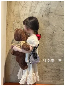 Detail of silver rhinestone handbag for girls with teddy bear and embroidered dress