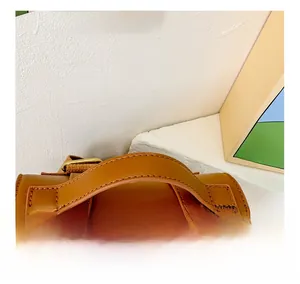 Detail of the comfortable brown faux leather handle with neat stitching on a retro backpack