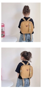 Détail d'un sac à dos enfant en toile kaki avec broderie ours et texte coréen mignon