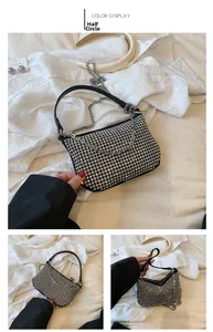 Detail of a black mini semi-circle bag featuring silver rhinestones and chain strap