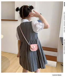 Pink PU mini crossbody saddle bag for girls worn by a model in a minimalist room