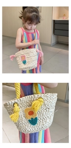 Detail of child straw bag with colorful floral embroidery and tassel shoulder straps