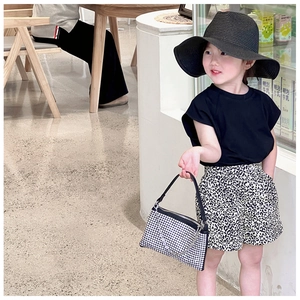 Mini-Handtasche mit silbernen Strasssteinen zu Leoparden-Shorts und schwarzem Sonnenhut