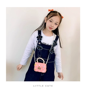 Mini sac rose en silicone avec poignée en perles et breloques porté par l'enfant