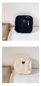 Détail du sac à dos en toile montrant la broderie ours et le ruban décoratif mignon