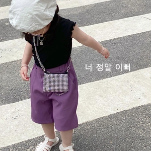 Girl's summer casual outfit with black ruffle top and sparkly rhinestone chain crossbody bag