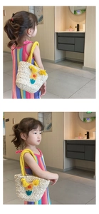 Close-up of handmade straw bag featuring yellow tassel and flower for kids fashion