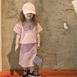 Girl's pink Amour T-shirt and skirt set with a sparkling rhinestone chain crossbody bag