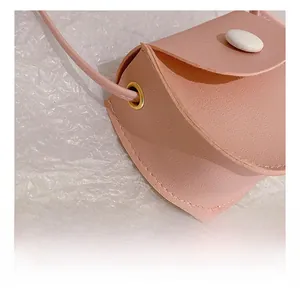 Close-up of pink PU leather texture with white button and gold metal grommet detail