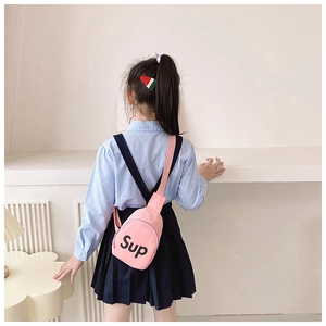 Close-up of pink canvas chest bag with black letter print on a girl in a casual outfit