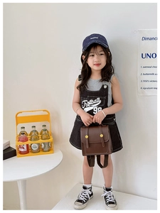 Close-up of a vintage brown PU leather children's backpack with gold metal buckles