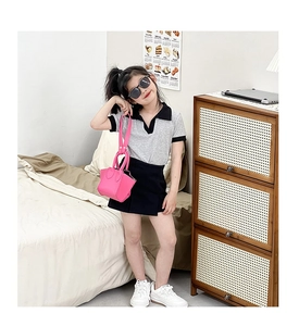 Toddler girl outfit featuring a grey polo shirt, black skirt, and bright pink mini purse