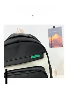 Détail du sac à dos maternelle avec contraste noir et blanc et étiquette mode verte