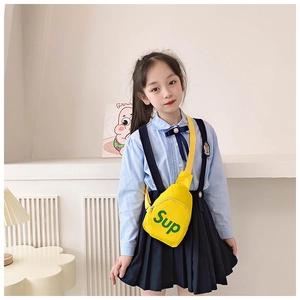 Detail of yellow canvas chest bag with green Sup lettering for stylish kids accessories