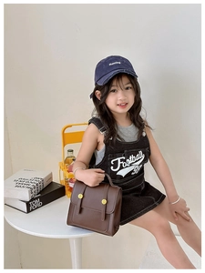Girl holding vintage brown PU leather backpack with double buckle at a white table