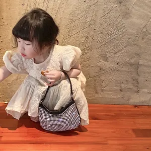 Sparkling silver rhinestone mini hobo bag for girls held by a child in a lace dress