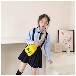 Detailed view of yellow canvas kids crossbody bag with green letter print and strap