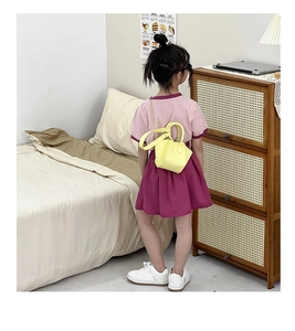 Toddler yellow PU leather handbag with metallic chain strap worn as a crossbody bag