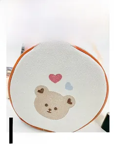 Détail du sac à dos en toile pour enfants avec ourson brodé et cœurs colorés