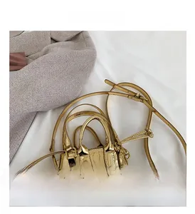 Detailed top view of a gold metallic mini shell bag with dual handles and slim shoulder strap