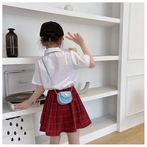 Rear view of a light blue mini PU crossbody bag worn by a child against a white background