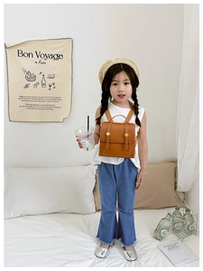Detail of children's vintage brown PU leather backpack with gold buckle and flap closure