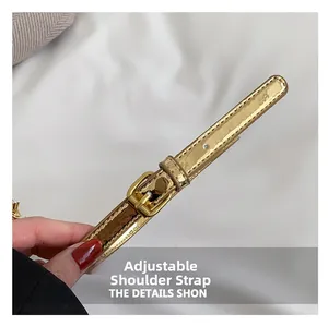 Detailed close-up of the adjustable gold patent leather shoulder strap with metal buckle