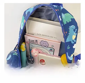 Detail showing high-capacity interior of blue kids dinosaur backpack with school supplies