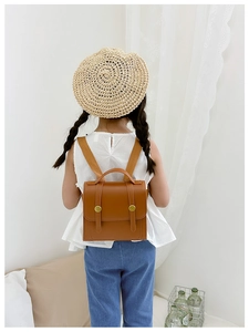 Rear view of a child wearing a vintage caramel brown PU leather mini backpack