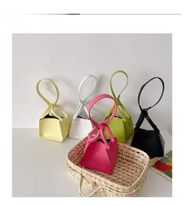 Macro detail of mini PU leather bucket bags in various colors with unique knotted handles