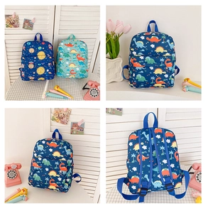Detail view of cartoon kids backpack featuring space and dinosaur patterns on canvas fabric