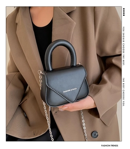 Detail der schwarzen Leder-Umhängetasche mit Silberkette und Fashion-Prägung