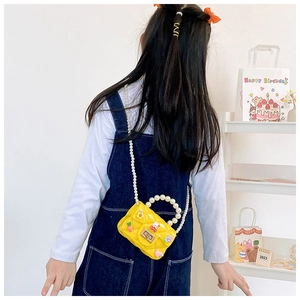 Détail du sac en silicone jaune matelassé avec chaîne en perles et charms en vue arrière