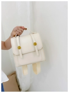 Detail view of cream PU leather mini backpack with flap closure and vintage gold buckles
