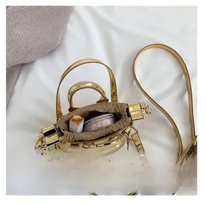 Internal view of mini gold lacquer bag showing storage space for lipstick and compact