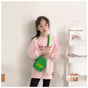 Detail of child green canvas chest bag with yellow lettering and mesh sleeve sweatshirt