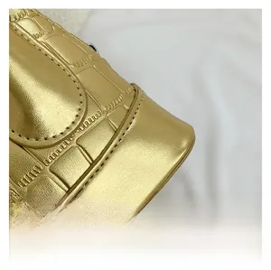 Close-up of golden shell crossbody bag showing detailed crocodile pattern texture